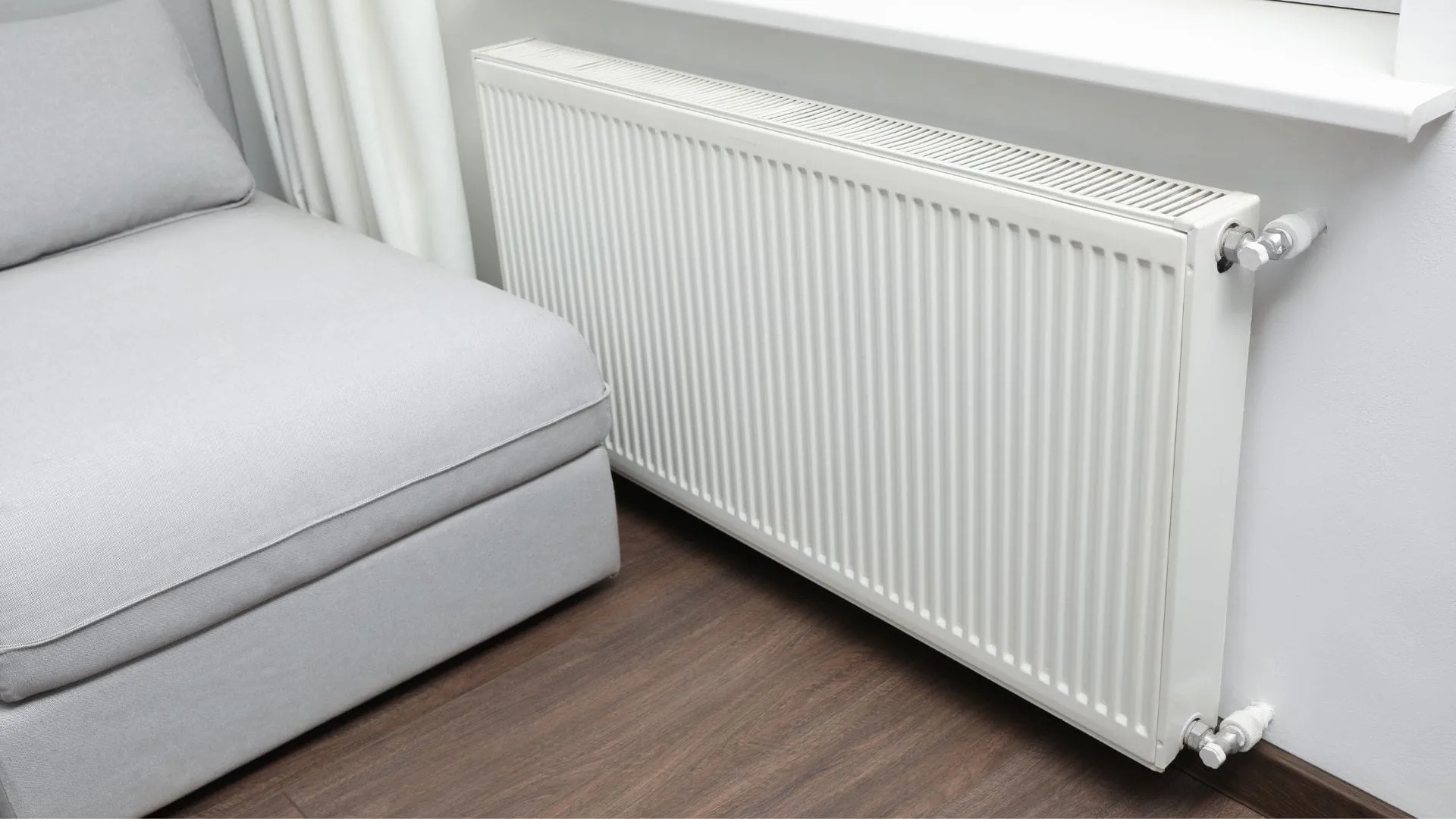 Witte radiator onder een raam in de woonkamer