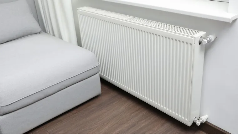 Witte radiator onder een raam in de woonkamer