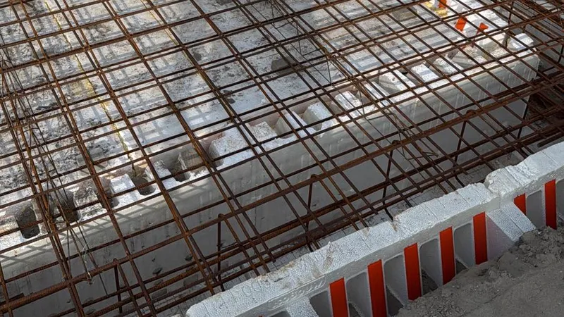 Wapeningsnetten in een geïsoleerde funderingsbekisting voor een aanbouw, klaar om te storten