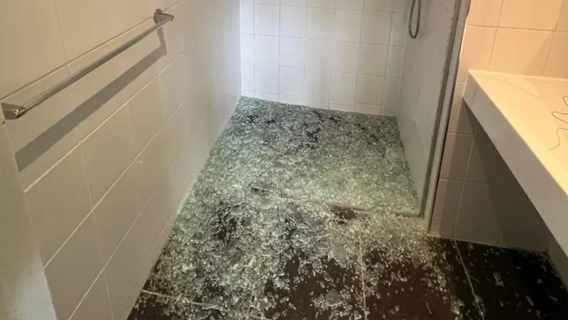 Oude doucheruimte met een vervuilde vloer, voor de renovatie