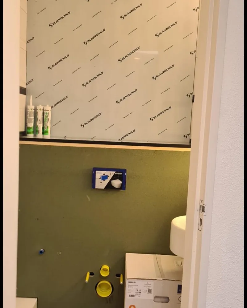Toiletruimte in aanbouw met ingebouwd reservoir achter vochtbestendige plaat, klaar voor het hangend toilet
