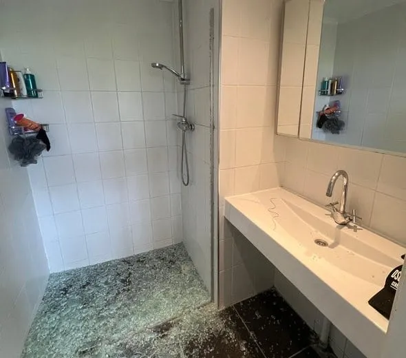 Oude badkamer met schimmel op de douchevloer voor renovatie