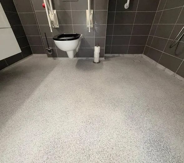 Afgewerkte epoxy vloer rond een hangend toilet