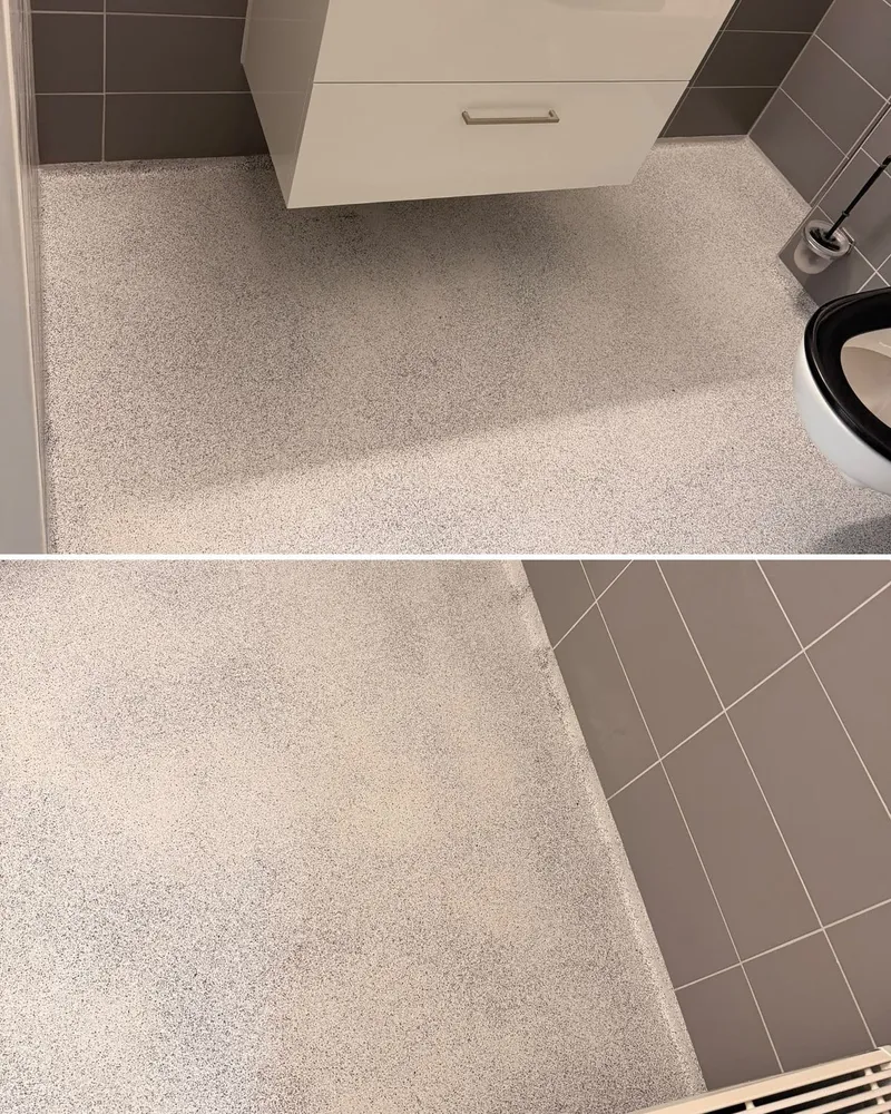 Afgewerkte epoxy vlokkenvloer bij het wastafelmeubel en in de doucheruimte met afvoerputje