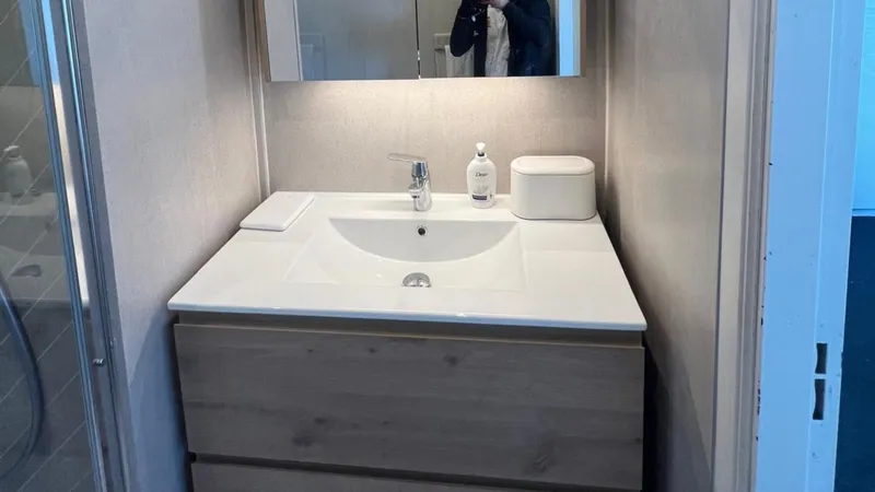 Wastafelmeubel met kraan en spiegelkast in een badkamer