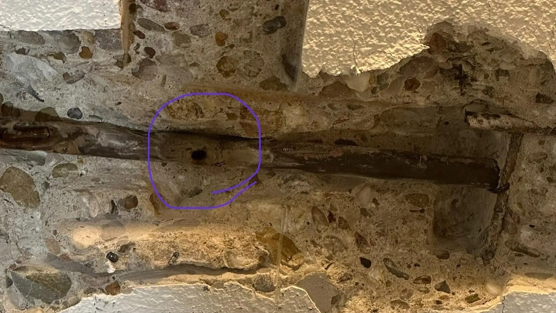 Opengehakte muur met de gevonden lekplek omcirkeld