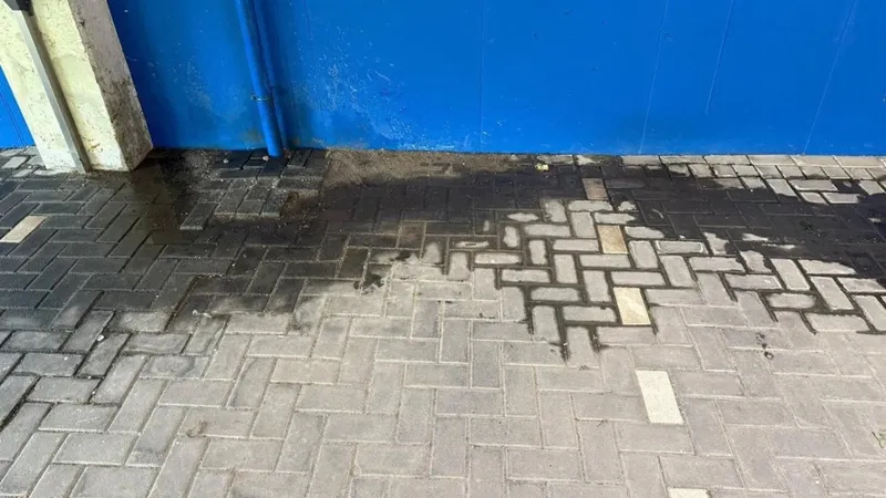 Donkere vochtplek op de bestrating wijst op een verborgen lekkage