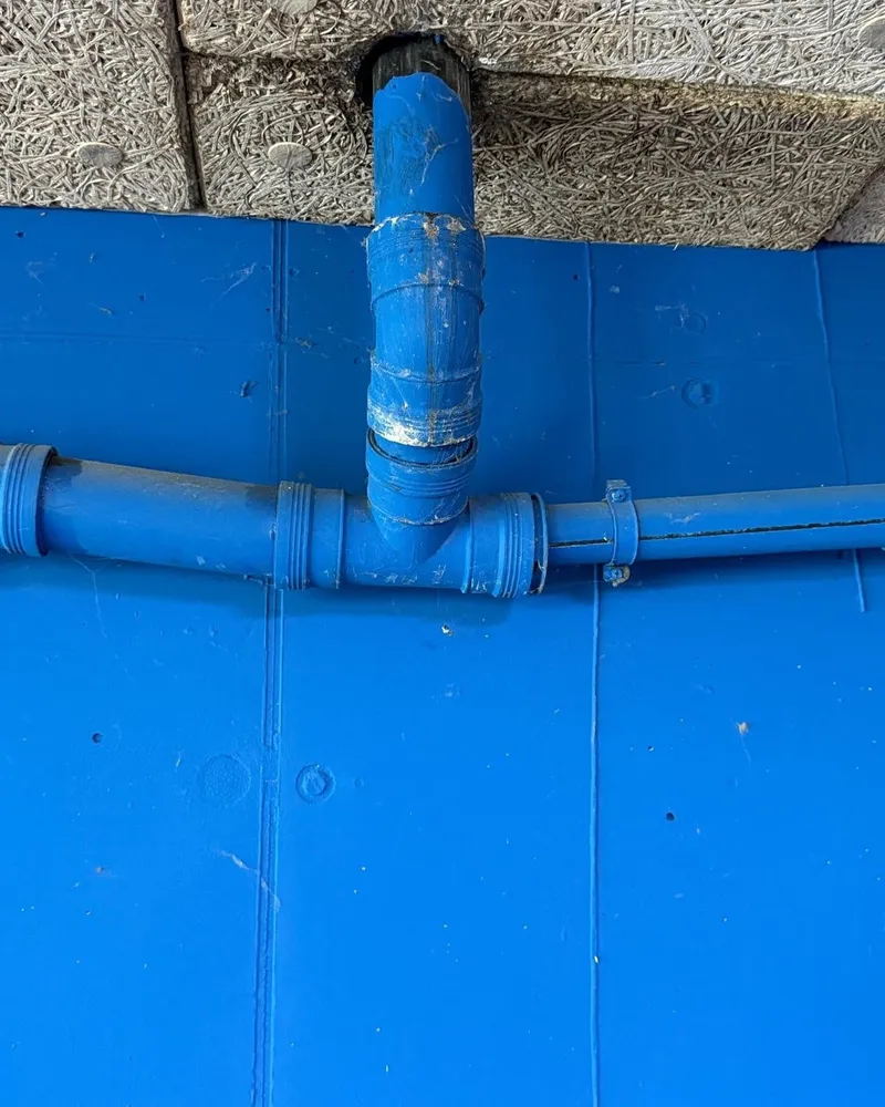 Close-up van een PVC T-stuk tegen het plafond