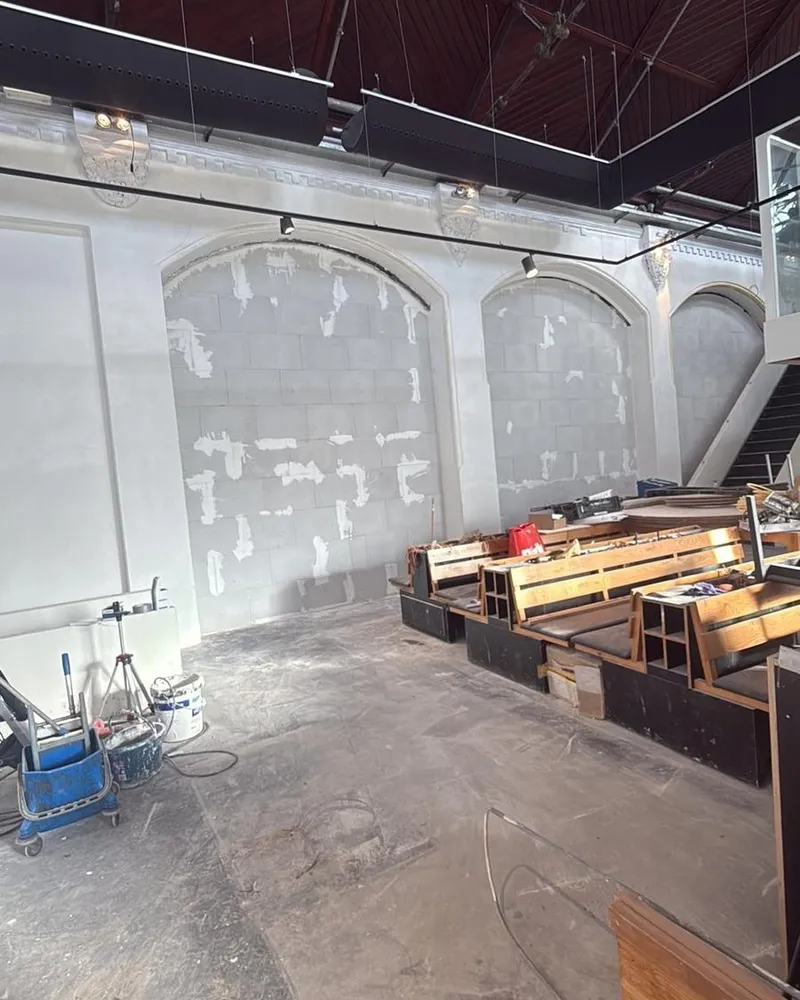 Gerenoveerde zaal met glad afgewerkte wanden en boogopeningen