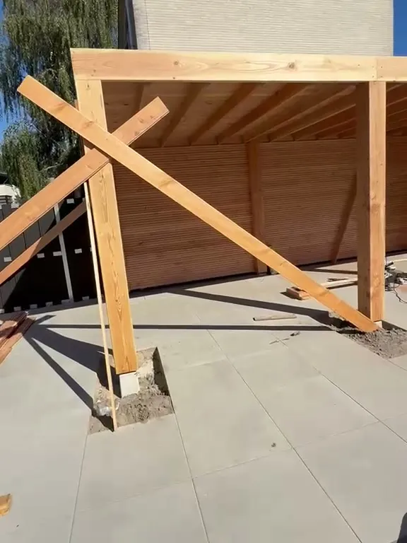 Houten overkapping met staanders, dakbalken en houten wandbekleding op een nieuw terras