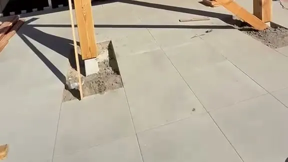 Houten staander van een overkapping op een betonnen poer in het terras