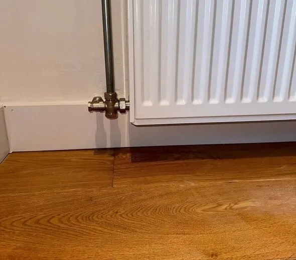 De radiatoraansluiting na herstel van het vochtprobleem